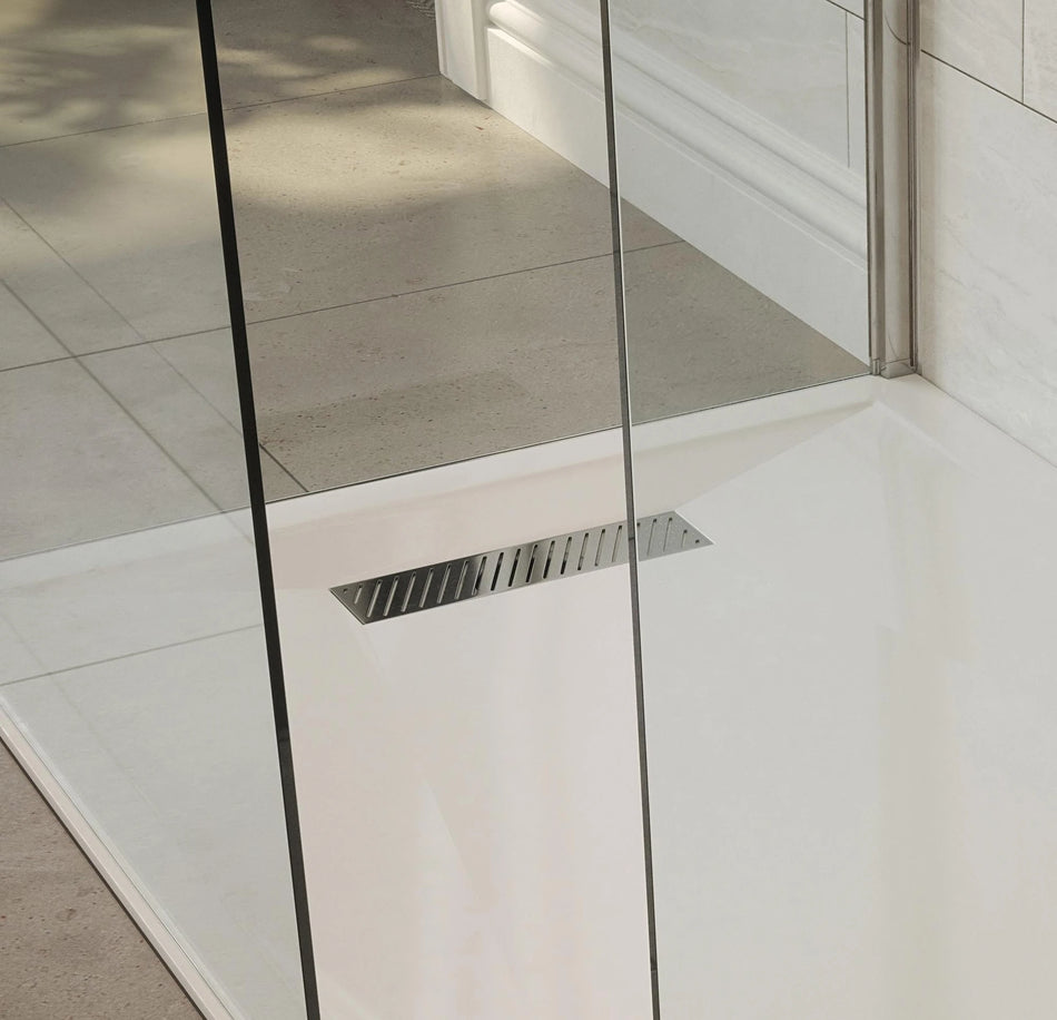 Chrome linear shower drain waste cover with slotted grate in white shower tray