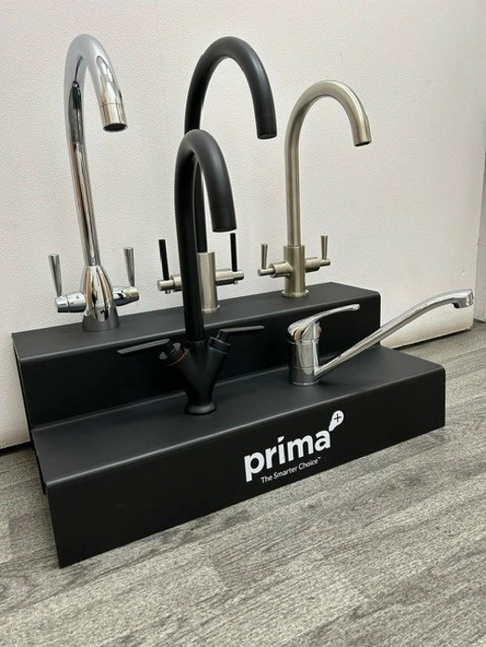 Prima deck sink taps in chrome and black with curved spouts on a base
